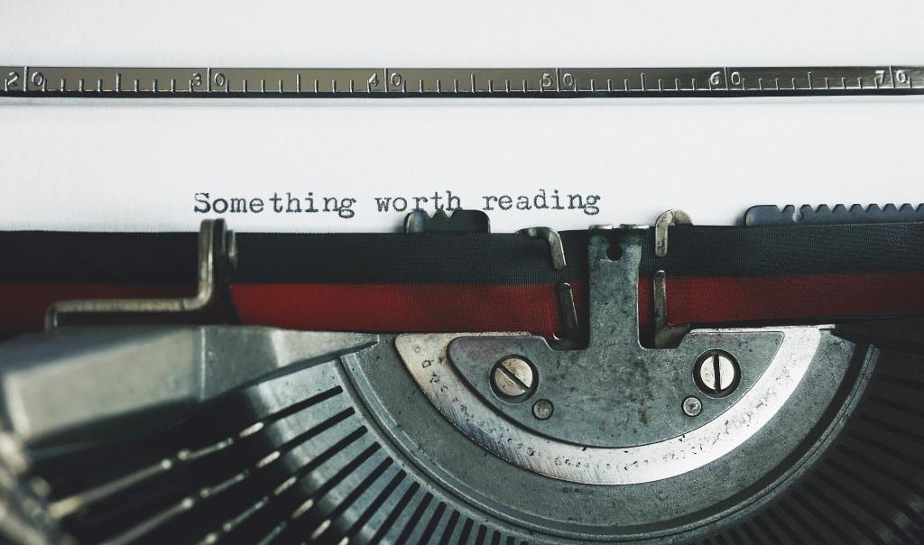 Typewriter with page showing "Something worth reading"