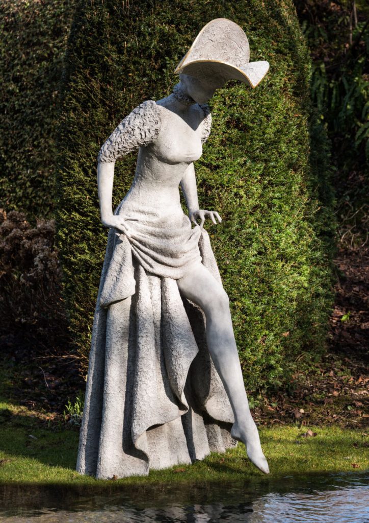 Statue of a costumed woman dipping her toes